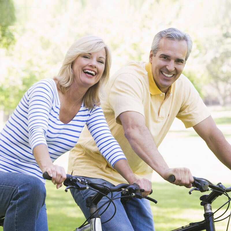 Man and woman riding bikes outside