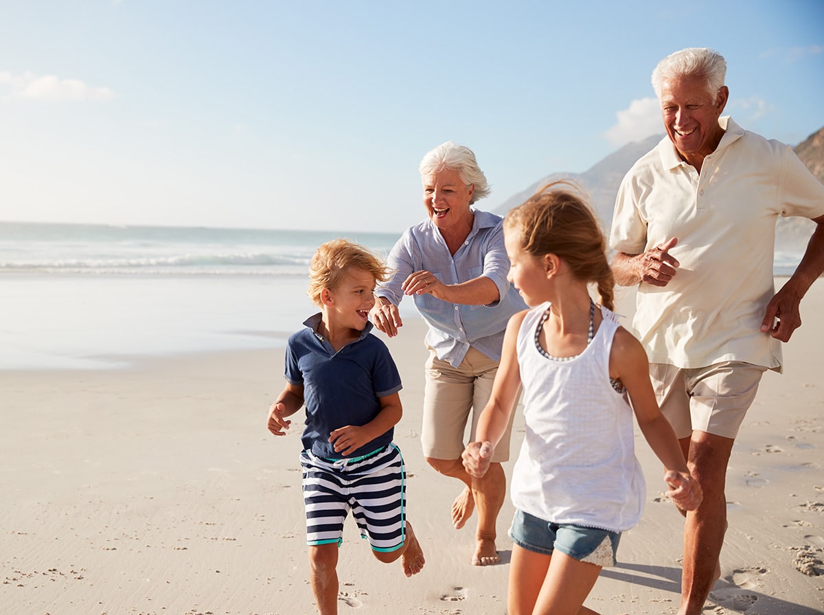 Grandparents and children having fun on a beach