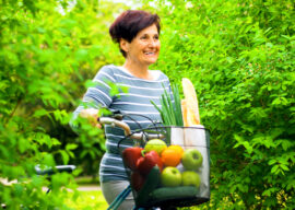 Older woman with a bike and basket of fruit and vegetables