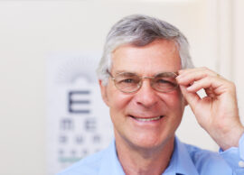 Older man wearing glasses in front of an eye chart