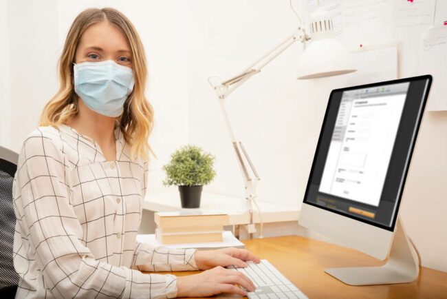 Woman wearing a mask at scheduling computer