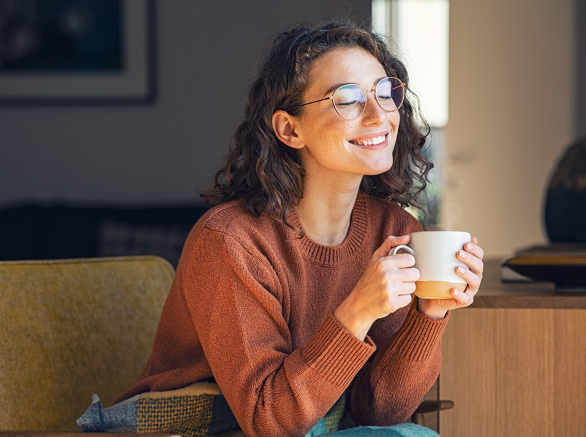 Woman enjoying a cup of coffee on a sofa